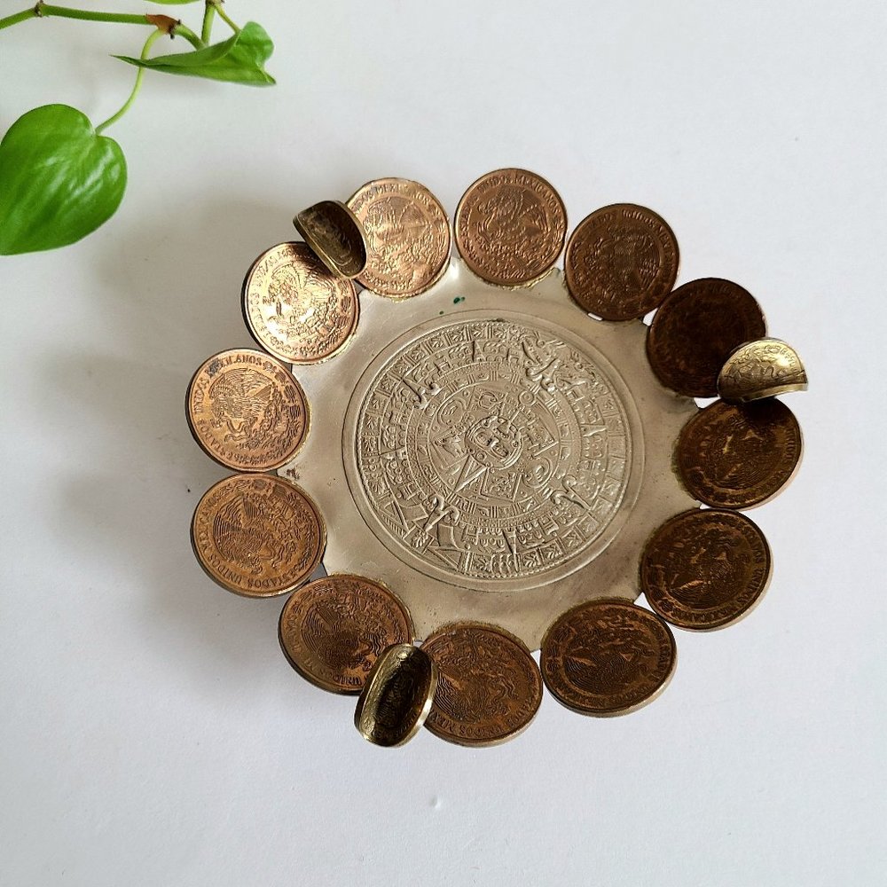 Handmade ashtray with coins and Mayan calendar.